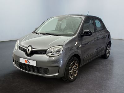 La petite voiture est garée dans une grande pièce au sol noir.