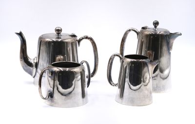 two silver teapots sitting next to each other on a white surface