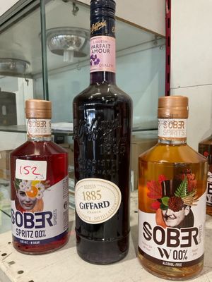 three bottles of alcohol sitting on a counter in front of a glass case