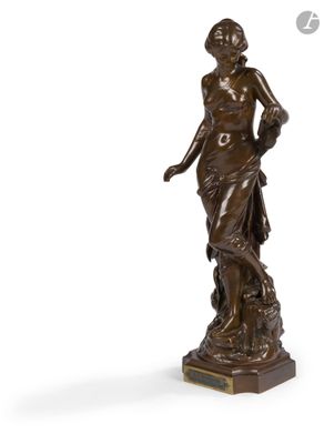 une statue de bronze représentant une femme debout sur un piédestal