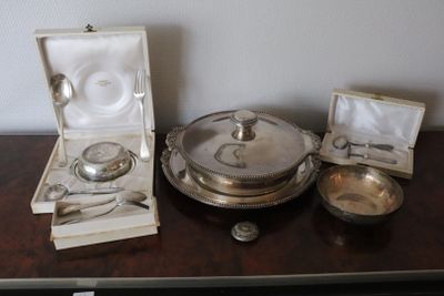a silver plate with spoons and a bowl on a table