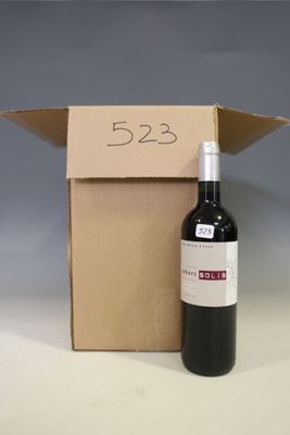 a bottle of wine sitting next to a cardboard box
