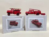 two red firetrucks sitting on top of a white box