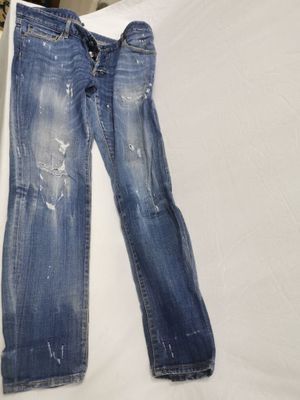 un pantalon en jean troué posé sur un lit dans une chambre