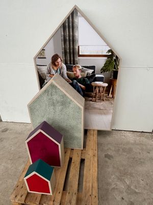 a woman that is sitting on a pallet in front of a house