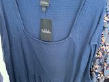a blue dress hanging on a rack in a clothing store