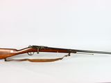 un vieux fusil posé sur une surface blanche, muni d'une crosse en bois