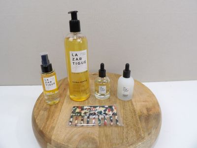 a wooden tray with a bottle of liquid, a bottle of lotion, and a bottle of lotion on it