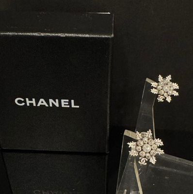 une boîte noire sur laquelle sont posées une paire de boucles d'oreilles