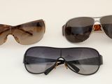 three pairs of sunglasses are shown on a white surface