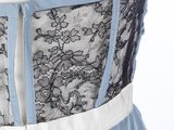 the back of a woman ' s dress with blue and white trims