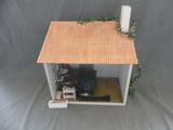 une petite maison de poupées avec un toit rouge et un toit marron