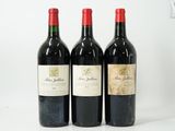 trois bouteilles de vin rouge sont alignées sur une surface blanche