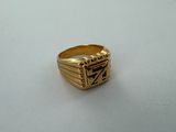 gros plan d'une bague en or sur une surface blanche