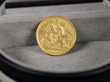 une pièce d'or posée dans un écrin sur une table