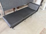 une photo d'une chaise longue noire dans un garage