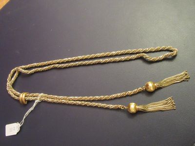 two gold tassels with tassels on a black surface