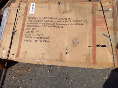 a cardboard box sitting on the ground with a sign on it