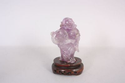 une petite figurine représentant un homme, ornée d'un cristal rose