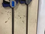 two clamps attached to a wall with a blue tag
