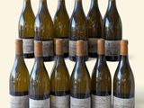 plusieurs bouteilles de vin sont alignées sur une surface blanche