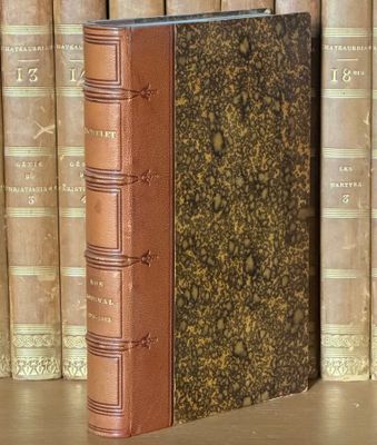un livre posé sur une table, devant une pile de livres