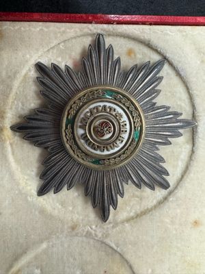 a silver and gold medal with a star on it