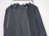 deux vestes suspendues à un porte-vêtements dans une pièce blanche