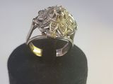 un gros plan d'une bague en diamant posée sur un présentoir noir