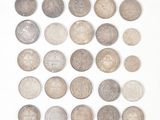 plusieurs types de pièces de monnaie sont disposés sur une surface blanche