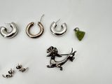 a lot of earrings and a pocket watch on the table
