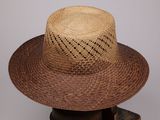 un chapeau de paille posé sur un support en bois