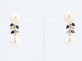 paire de boucles d'oreilles ornées de perles et de saphirs sur un support