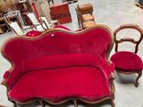 un canapé rouge et deux fauteuils dans une pièce