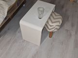 a small table with a glass on it in a living room
