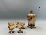 quatre verres à vin et un vase doré posés sur une table