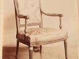 une vieille photo d'une chaise dont l'assise est recouverte d'un tissu à motifs floraux