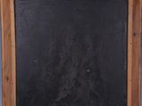an old wooden frame with a blackboard hanging on the wall