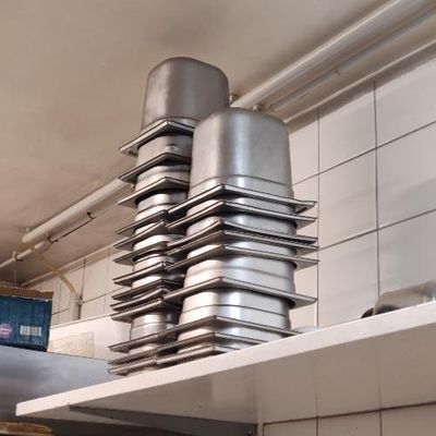 plusieurs casseroles empilées les unes sur les autres sur une étagère dans une cuisine
