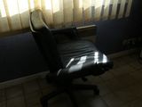 a black office chair sitting in front of a window