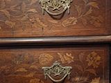 a wooden chest of drawers with floral designs on it