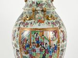 a vase with a painting on it sitting on a table