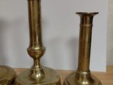 three brass candles sitting on a table next to a lamp