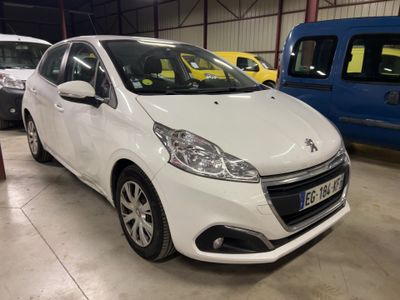 La petite voiture blanche est garée dans le garage, à côté d'autres voitures.