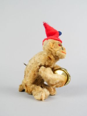 un petit ours en peluche avec un bonnet rouge et une clochette