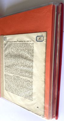 an open book with a red cover on a table
