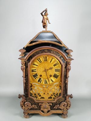 une horloge sur laquelle trône une statue, posée sur une table