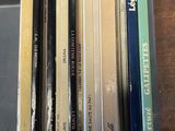 une pile de livres posée sur un bureau, à côté d'un clavier