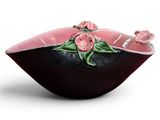 pink and black bowl with flowers on it on a white background