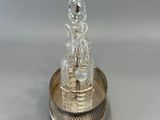 a silver plate with a glass bottle on top of it
